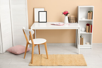 Interior of room with workplace, bookshelf and folding screen
