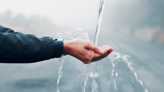 Outdoor, hands and person with water splash, cleaning and hydration with wellness. Closeup, hygiene or liquid with routine, healthy or prevent germs with nature, washing and remove bacteria with aqua