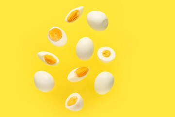 Flying boiled chicken eggs on yellow background