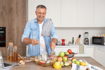 Mature man with sugar making apple cider in kitchen