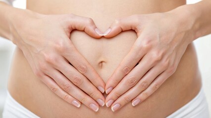 A pair of hands forming a heart shape over a pregnant belly, symbolizing love and anticipation for the unborn child.
