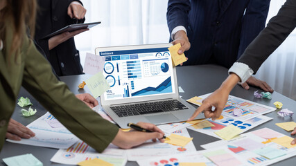 Analyst team use sticky note for creative and analytic brainstorm for business idea with BI data dashboard on laptop screen. Analysis financial data visualization tech for marketing strategy. Prodigy