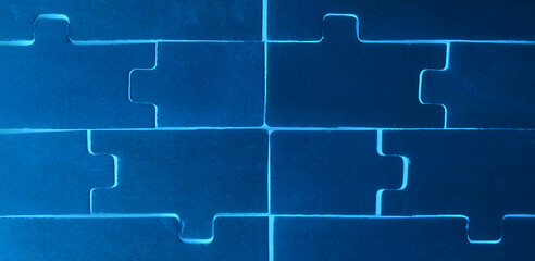 A solid texture of blue puzzle shaped pieces with bright blue seams between them  