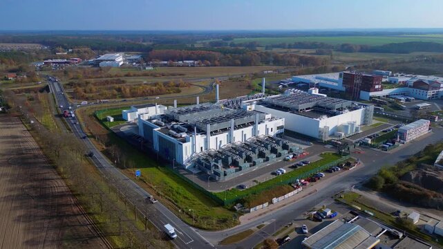 Modern big data center facility standing in an industrial area, serving digital information and connectivity. Majestic aerial view flight wide orbit overview drone