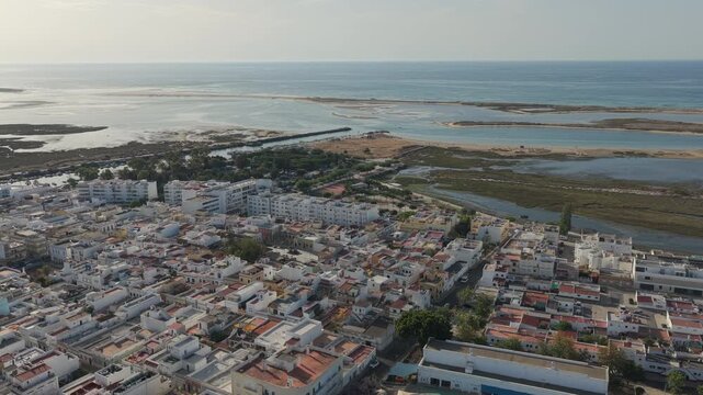 Drone advances over Fuseta toward Ria Formosa shoreline.