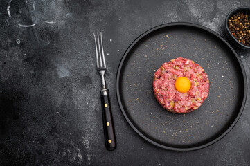 Beef tartare with yolk on black dish against dark backdrop great for gourmet cooking protein rich meals and high quality food photography.