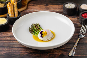 Poached egg served with asparagus and buttery golden sauce