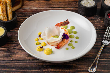 Elegant shrimp dish served with colorful sauces and edible flowers