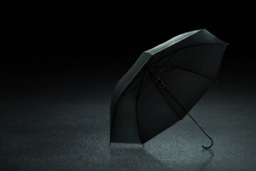 Black umbrella on the street with asphalt road background
