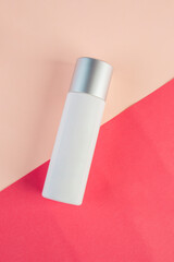 White cosmetic product or sunscreen cosmetic with stylish props on light orange background.