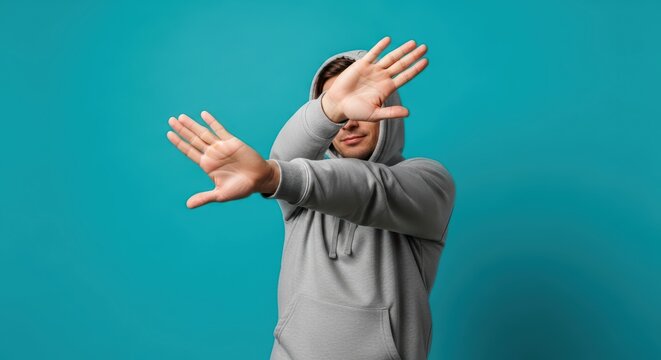 Young caucasian male in hoodie gesturing against blue background