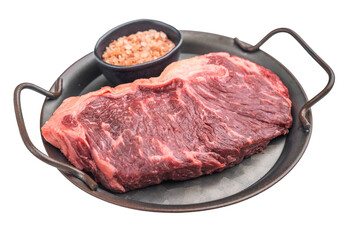Raw dry aged striploin steak with marbling and Himalayan salt in a rustic metal pan on a light background, perfect gourmet beef food shot.