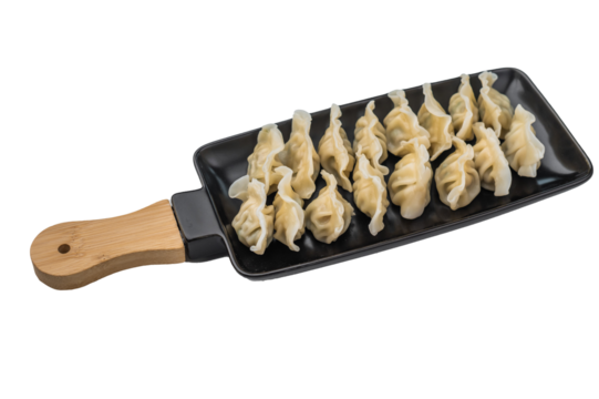 Neatly arranged boiled jiaozi gyoza mandu dumplings on black plate top view ideal for Asian cuisine menus and food photography.