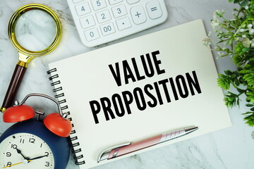 Value Proposition text written on notepad with alarm clock, magnifying glass and calculator on...