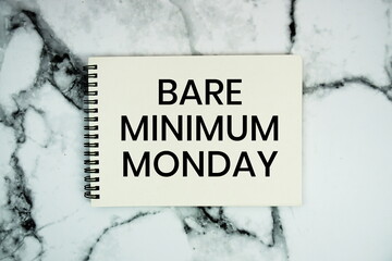 Bare Minimum Monday text written on notepad flat lay on marble background