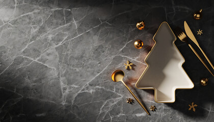 Celebrate the holidays with elegance a modern Christmas dinner setting featuring a stylish Christmas tree shaped plate and golden cutlery on gray marble