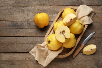 Tray with sweet ripe quinces on wooden background