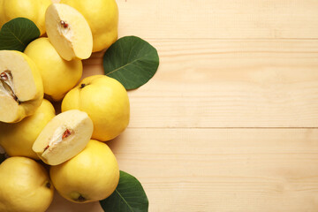 Sweet ripe quinces and leaves on wooden background