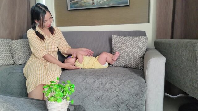 A mother playfully placing a teething toy into her baby&rsquo;s mouth to stimulate healthy gum development