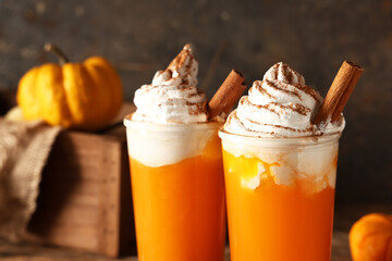 Glasses of orange pumpkin spice latte on black grunge background, closeup