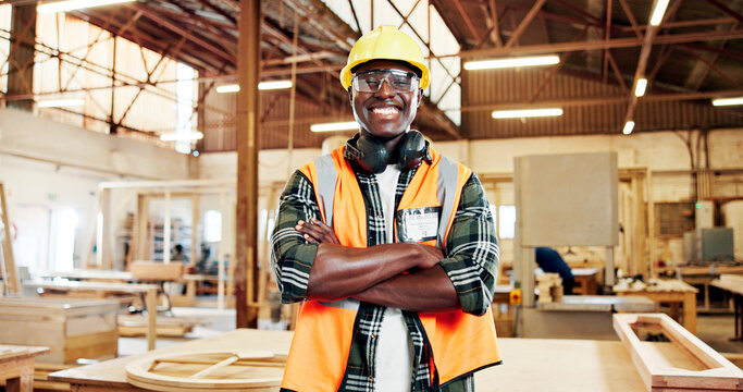 Carpentry, crossed arms and portrait of black man in workshop for production, construction and woodworking. Carpenter, safety gear and person in factory for wood, lumber and timber manufacturing