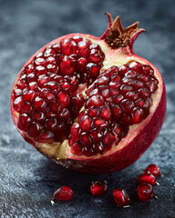 single pomegranate split open with glowing ruby seeds, luxury food macro shot, dark premium backdrop