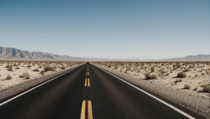 Fototapeta premium Empty highway stretches into a vast desert landscape under a clear sky. Mountains are visible in the distance