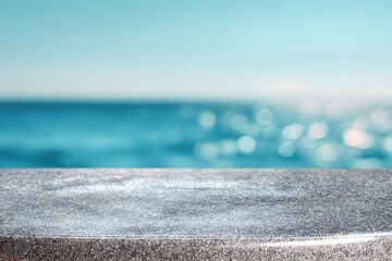 Grey stone surface against blurred ocean, serene backdrop