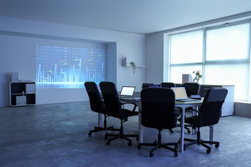 Interior of data scientist's office with workplace, laptops and diagrams projection on wall