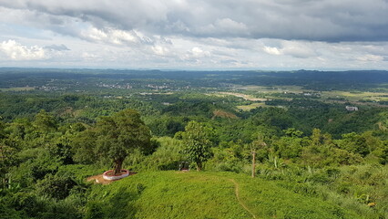 Fototapeta premium Lush Green Hills and Valleys Under a Dramatic Sky A Serene Natural Vista