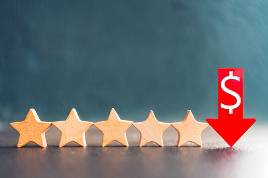 Wooden star rating and red down arrow with dollar symbol represent dollar devaluation, declining economic value, currency rating downgrade, financial crisis, and monetary instability.