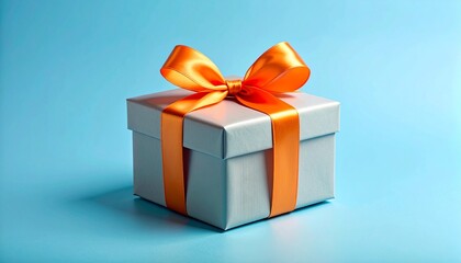 Obraz premium White gift box with orange ribbon on light blue surface, symbolizing celebration and cheerful generosity.