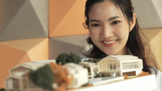 Skilled attractive architect engineer holds architect model while checking mistake point carefully. Project manager inspect architectural model by lifting left side and right side. Manipulator.