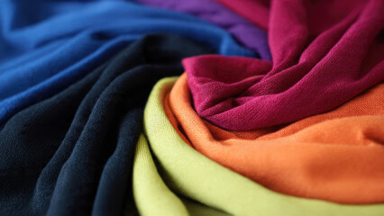 Vibrant textiles of various colors arranged in a beautiful, flowing spiral pattern, showcasing rich hues and soft textures, perfect for design inspiration.