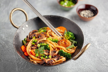 Wok noodles with mushrooms, broccoli, carrots and green onions.
