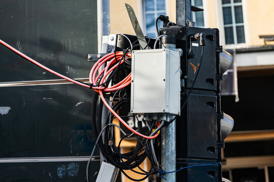 Wires and control box on traffic signal in urban setting during day
