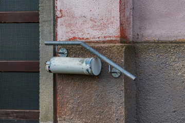Handrail and mailbox attached to wall with a mounted pipe support