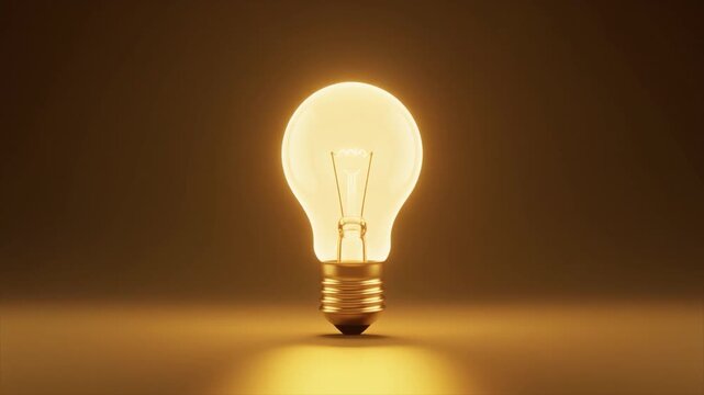 Illuminated incandescent light bulb with a bright yellow glow and visible filament on a warm background