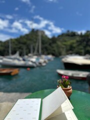 Menu on the table in a cafe against the background of the sea with boats and yachts