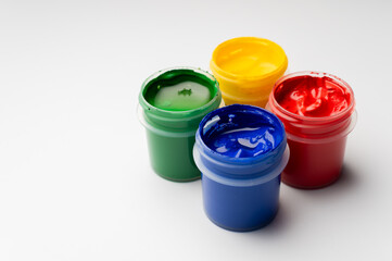 group of jars of gouache on a white background. Jars of gouache of different colors