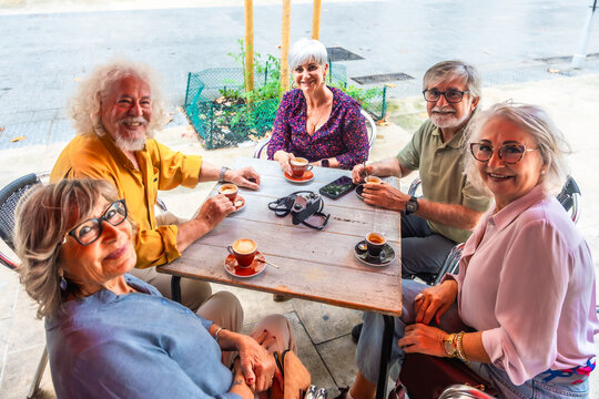 Senior friends enjoying coffee cups at outdoor cafe - Powered by Adobe