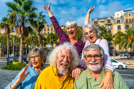 Cheerful senior friends enjoying group travel in city