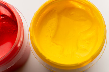 Painting tools, workspace, open can of thick yellow paint, gouache. Painting as a hobby or craft, artistic macro background