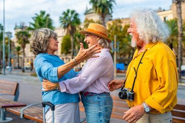 Senior friends hugging outdoors on urban street