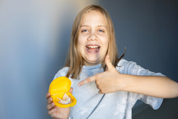 Girl smiles and shares excitement while holding a small toy in a bright room during daytime