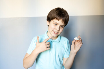 Young boy shows off his artwork with a proud smile in a bright room