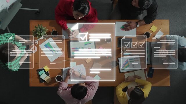 A diverse group of professionals engages in a collaborative business meeting, analyzing data and discussing strategies to achieve common goals in a modern office space. Raster