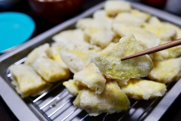 揚げたてさつまいも天ぷらの山盛りイメージ。家庭料理。