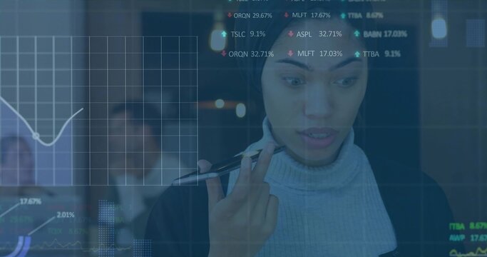 Studying woman in turtleneck and blazer holding pen in office, glass display with financial charts