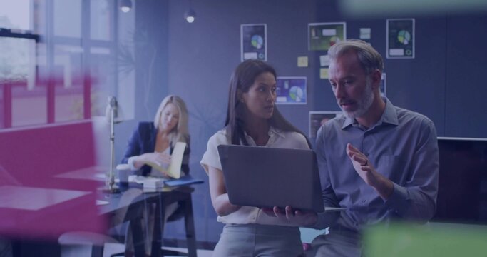 Holding laptop, coworkers in business attire gesturing and explaining screen in office with charts - Powered by Adobe